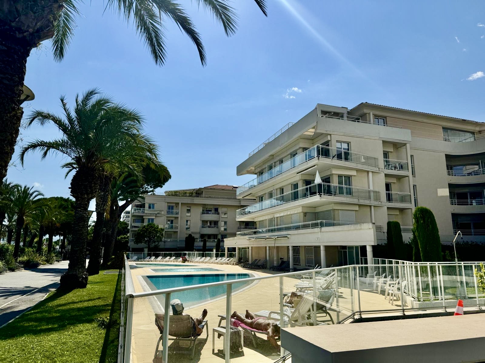 Résidence Royal Palm à Cannes-la-Bocca : façades claires, piscine et jardins bordés de palmiers